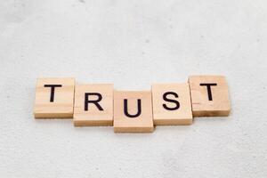Top view of Trust word on wooden cube letter block on white background. Business concept photo