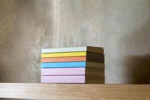 Stack of colorful books on floating wooden bookshelf. Education and knowledge concept. Pile of books to read. House interior decoration photo