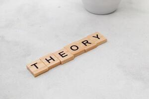 Top view of Theory word on wooden cube letter block on white background. Business concept photo