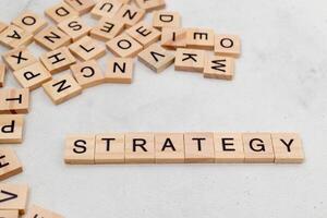 Top view of Strategy word on wooden cube letter block on white background. Business concept photo