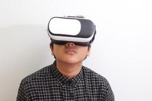Portrait of Asian man in black plaid shirt using Virtual Reality VR glasses and looking up. Isolated image on white background photo