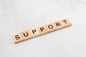 Top view of Support word on wooden cube letter block on white background. Business concept photo