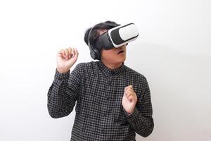 Portrait of Asian man in black plaid shirt using Virtual Reality VR glasses and playing racing games and making hand gestures like driving. Isolated image on white background photo