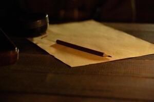 A sheet of paper with a pencil on the table in the dugout in the semi-darkness photo