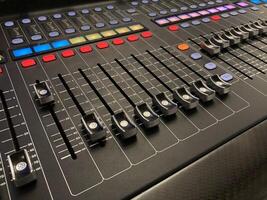 a close up of a mixing board with multiple knobs photo