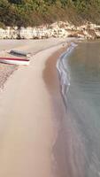 A boat is sitting on the beach next to a cliff video
