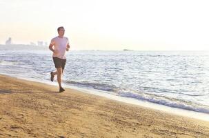 Man running on the beach at surise photo
