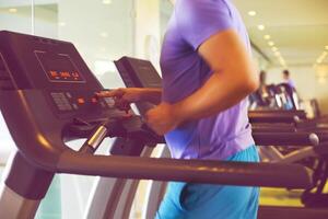 Healthy young man training on a treadmill in a sport center photo