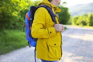 Side view of young man with backpack hiking photo