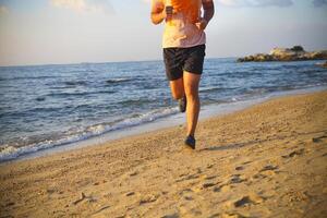 Man running on the beach at sunset photo