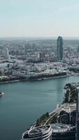 Tall buildings with blue windows taken from a drone. Stock footage. A magnificent landscape of a big city with beautiful houses and parks around the river. video
