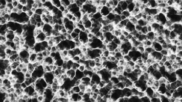 Bright glowing liquid boils on surface. Motion. Moving texture on surface of liquid plasma. Glowing plasma with black moving molecules video
