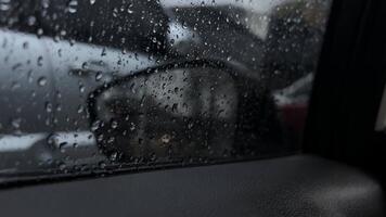 Rain droplets gently slide down the glass, creating a harmonious blend with the reflections. video