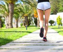 Runner feet running on road closeup on shoes photo