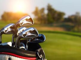 Golf clubs drivers over green field background photo