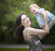 Beautiful young mother with daughter in summer park photo