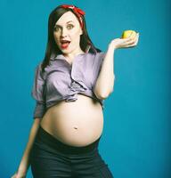 Happy young funny pregnant woman in pin up style photo