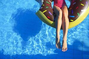 Young woman on inflatable mattress in the swimming pool photo