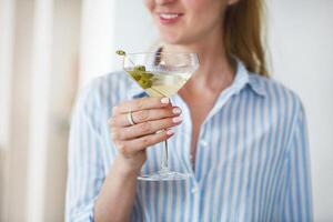 Glass with martini and green olives photo