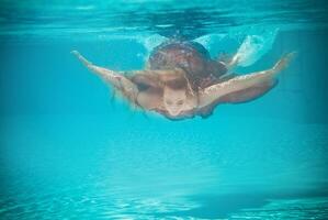 Underwater woman portrait in swimming pool photo