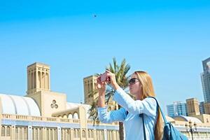 Woman taking mobile photo of the Central Souq in Sharjah City, United Arab Emirates