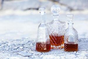 Three whiskey decanters against a light gray background photo