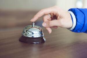 Hand of a woman using a hotel bell photo