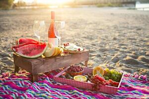 Picnic with rose wine, fruits, nuts meat and cheese photo