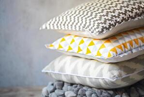 Yellow and grey pillows on the wall background photo
