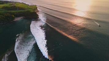 Swell lines waves in ocean with evening sunlight in Bali, drone view video