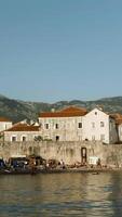 Montenegro, Budva - June 1, 2022. Beautiful view of coast with old stone town on background of mountains. Creative. Beautiful ancient city on seashore in Europe. Historic city with beautiful ancient video