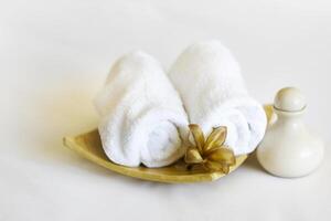Spa setting with towels aroma oil bottle and hand made orchid flower. photo