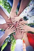 Group of friends with their hands in a complete circle photo
