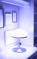 Glowing lamp on table with empty frames above photo