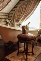 Close-up of a glass of wine and a bottle in an ice bucket on an elegant chair in the bathroom photo