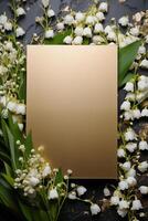 mockup of a postcard on gold paper A5 format in lily of the valley flowers on a dark background top view photo