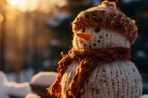 Close up of snowman with knit hat in the snow at sunset photo