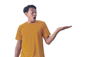 Portrait of an Asian man wearing a orange T-shirt, expressing surprise and shock with open palms, isolated against a white background. photo