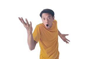 Portrait of an Asian man wearing a orange T-shirt, expressing surprise and shock with open palms, isolated against a white background. photo