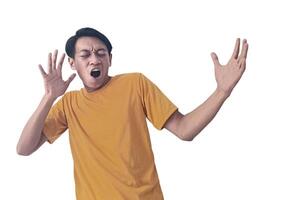 Portrait of an Asian man wearing a orange T-shirt, expressing surprise and shock with open palms, isolated against a white background. photo