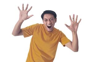 Portrait of an Asian man wearing a orange T-shirt, expressing surprise and shock with open palms, isolated against a white background. photo