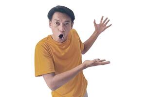 Portrait of an Asian man wearing a orange T-shirt, expressing surprise and shock with open palms, isolated against a white background. photo