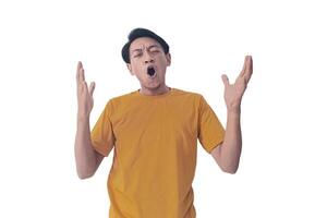 Portrait of an Asian man wearing a orange T-shirt, expressing surprise and shock with open palms, isolated against a white background. photo