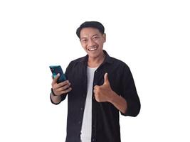 Young asian man holding mobile phone surprised in casual shirt showing copy space on palm isolated on white background. Good offer concept photo