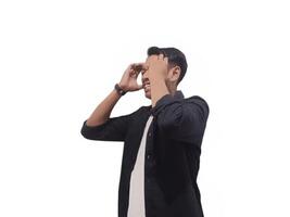 A man in a black shirt holds his head with a pained expression, indicating a headache or discomfort. The plain white background emphasizes his distress and highlights his posture and expression. photo