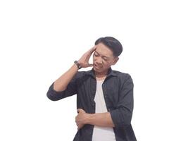 A man in a black shirt holds his head with a pained expression, indicating a headache or discomfort. The plain white background emphasizes his distress and highlights his posture and expression. photo