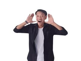 Surprised young handsome Asian man looking upward with raised hands isolated on white background photo