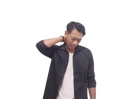 A man in a black shirt holds his neck with a pained expression, indicating discomfort or neck pain. The plain white background emphasizes his distress and highlights photo