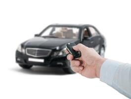A person holding a remote control in front of a car photo