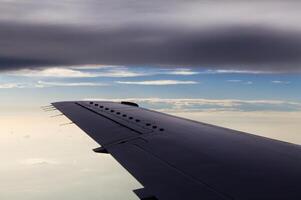 Commercial Aircraft Wing In Flight Between Two Layers Of Clouds photo